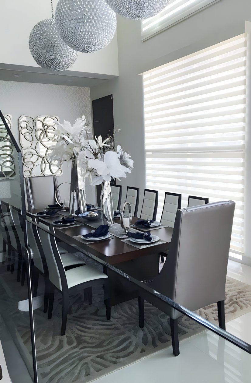 dual sheer shades in a modern dining room with crystal chandeliers