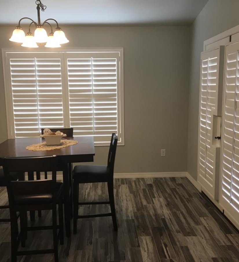 white plantation shutters on a window and matching sliding door panel