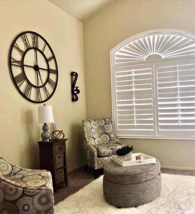white plantation shutters with sunburst arch window in a living room sitting area