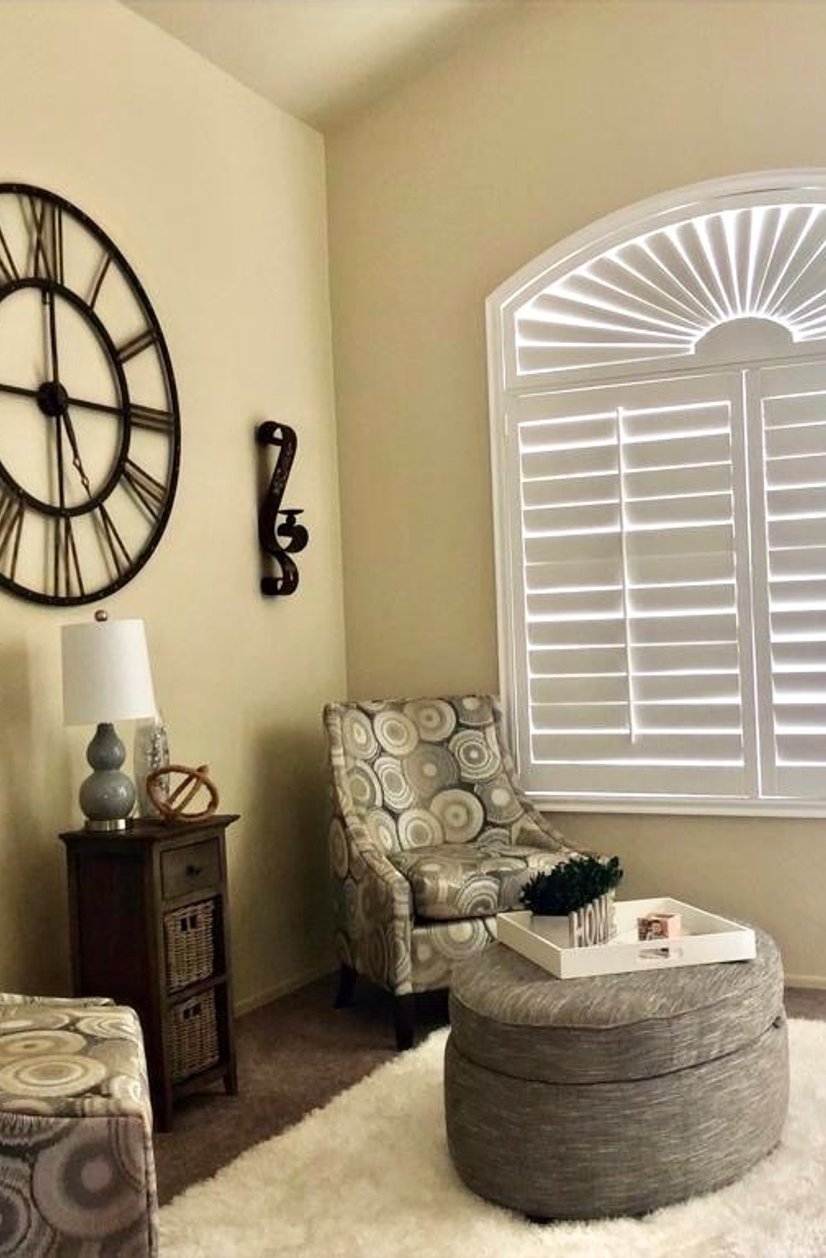 white plantation shutters with sunburst arch window in a living room sitting area